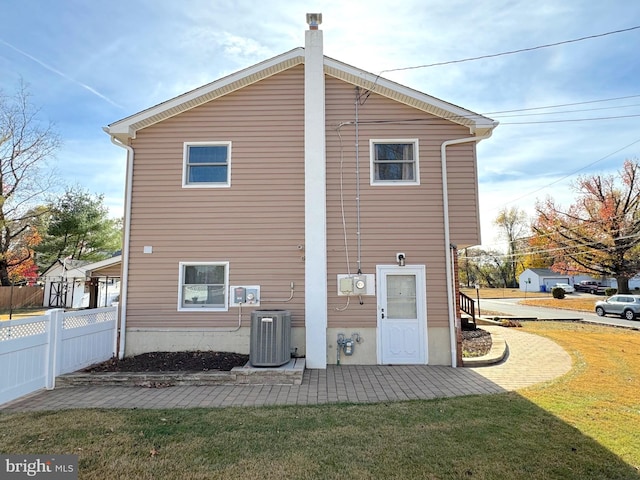 back of property with a lawn and central air condition unit