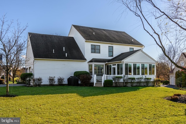 rear view of property featuring a sunroom and a lawn