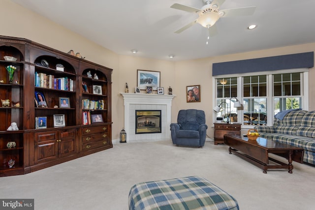 living room with light carpet, a fireplace, and ceiling fan