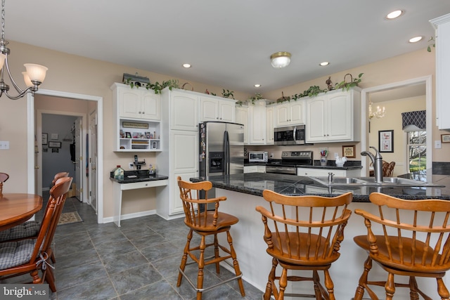 kitchen with kitchen peninsula, white cabinetry, sink, and appliances with stainless steel finishes