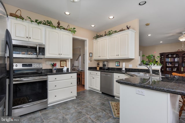 kitchen with white cabinetry, sink, ceiling fan, stainless steel appliances, and kitchen peninsula