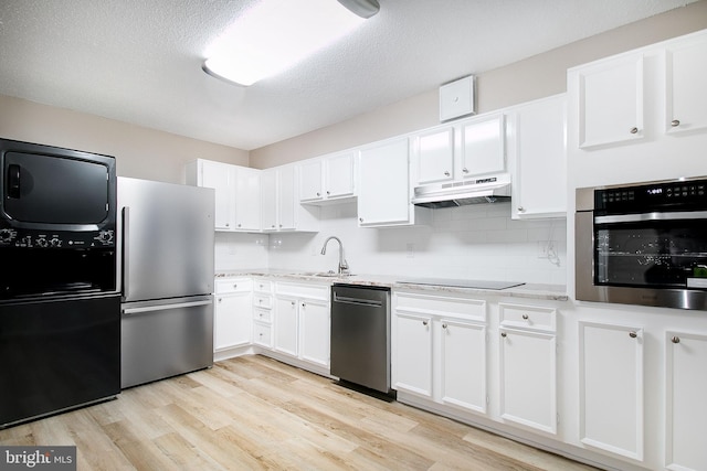 kitchen featuring appliances with stainless steel finishes, tasteful backsplash, sink, light hardwood / wood-style floors, and white cabinetry