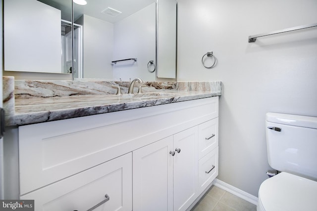 bathroom featuring tile patterned flooring, vanity, and toilet