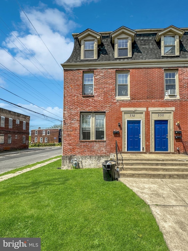 view of front of home with cooling unit and a front yard