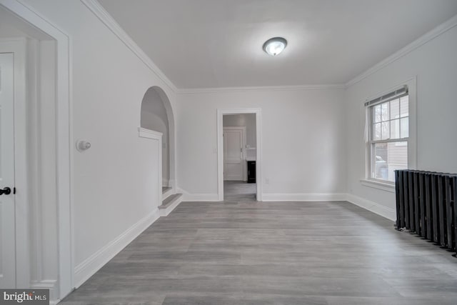 empty room featuring crown molding and light wood-type flooring