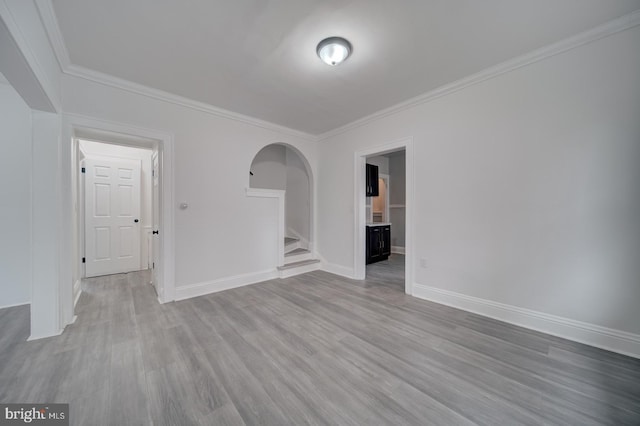 empty room featuring light hardwood / wood-style flooring and ornamental molding