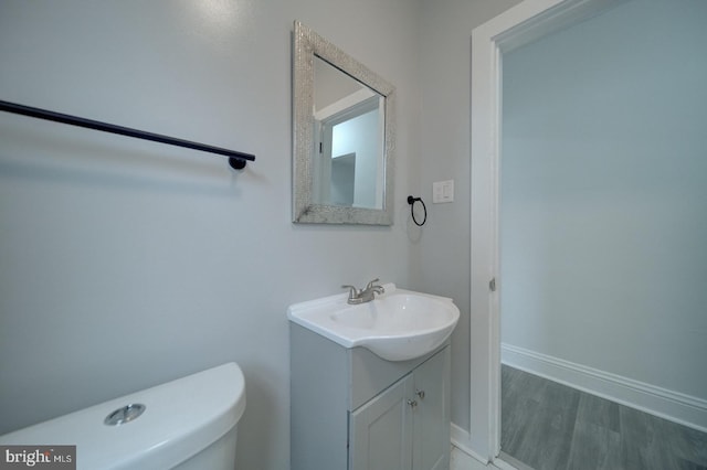 bathroom with vanity, hardwood / wood-style floors, and toilet