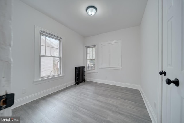 empty room featuring hardwood / wood-style floors and radiator