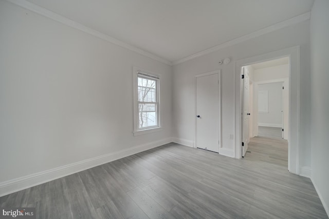 spare room featuring crown molding and light hardwood / wood-style flooring