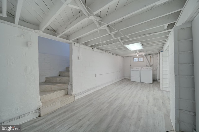 basement featuring independent washer and dryer and light hardwood / wood-style floors