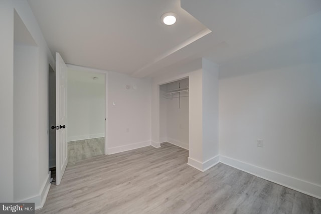 unfurnished bedroom featuring light hardwood / wood-style floors and a closet