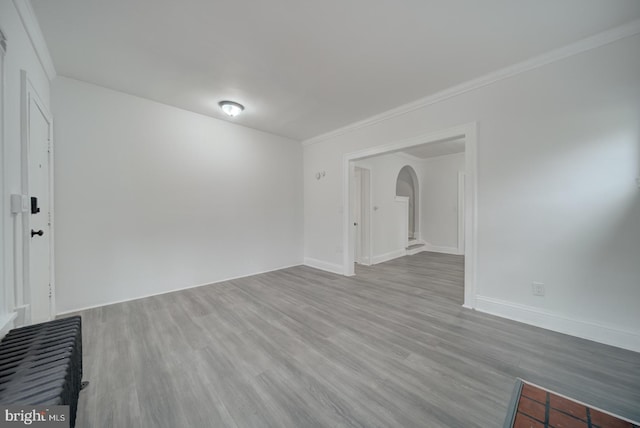 unfurnished room featuring ornamental molding and light wood-type flooring