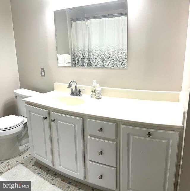 bathroom featuring tile patterned flooring, vanity, and toilet