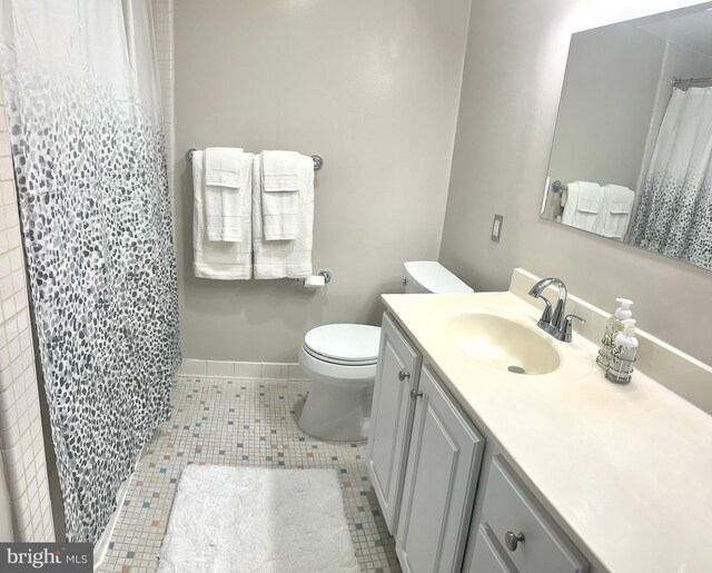 bathroom featuring tile patterned flooring, vanity, and toilet