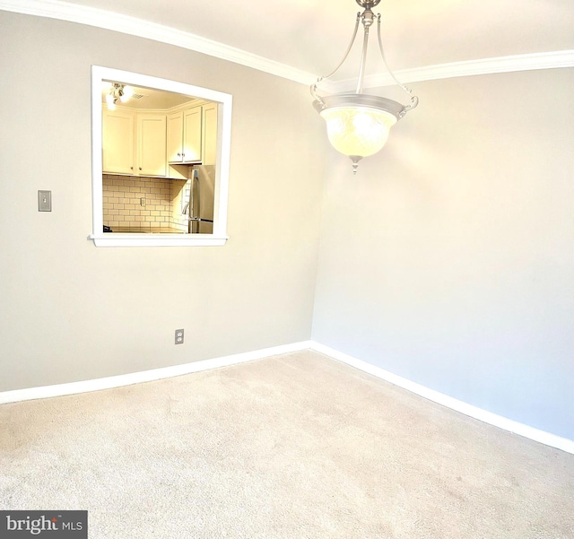 spare room featuring crown molding and carpet