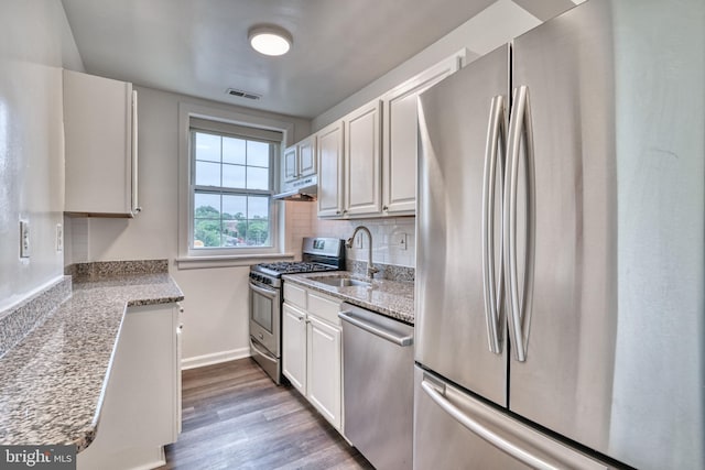 kitchen with white cabinets, wood-type flooring, stainless steel appliances, and sink