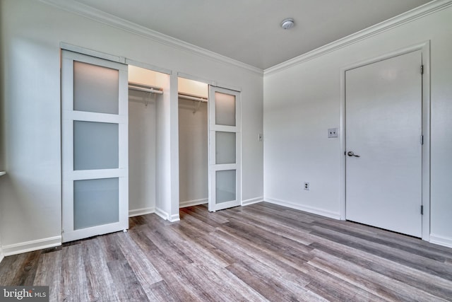 unfurnished bedroom featuring crown molding and wood-type flooring