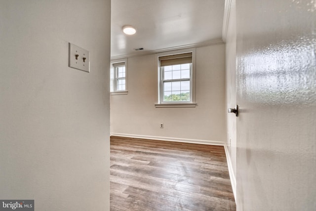 spare room with hardwood / wood-style floors and ornamental molding