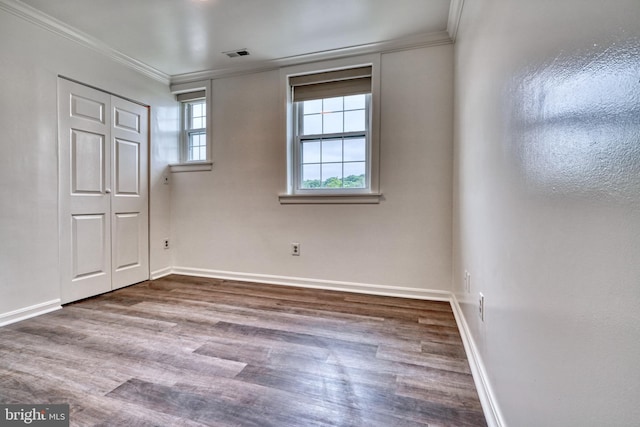 unfurnished bedroom with crown molding, a closet, and wood-type flooring