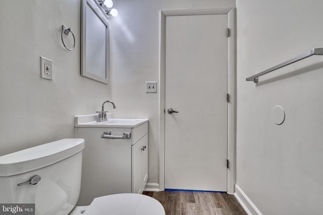 bathroom featuring vanity, wood-type flooring, and toilet