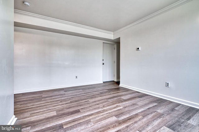 empty room featuring wood-type flooring and ornamental molding