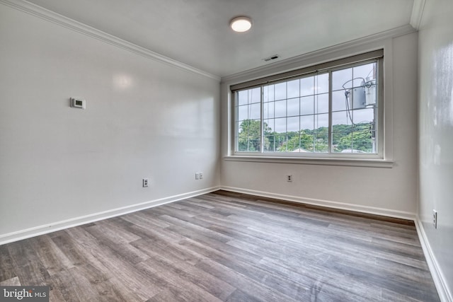 spare room featuring hardwood / wood-style floors and ornamental molding