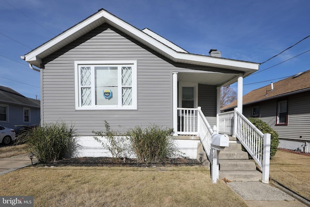 bungalow-style home featuring a porch and a front lawn