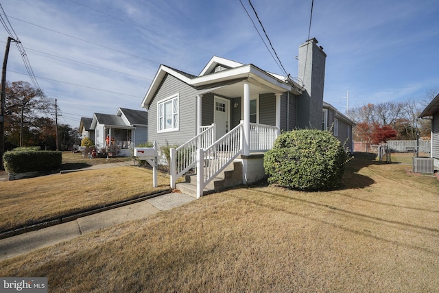 bungalow featuring central AC and a front lawn