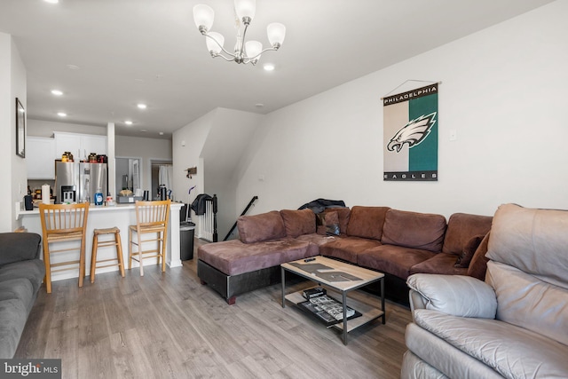 living room featuring a notable chandelier and light wood-type flooring