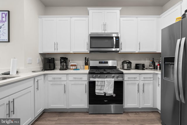 kitchen with white cabinetry, dark wood-type flooring, and appliances with stainless steel finishes