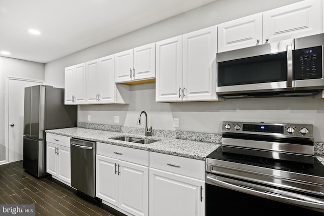 kitchen featuring white cabinets, appliances with stainless steel finishes, dark wood-type flooring, and sink