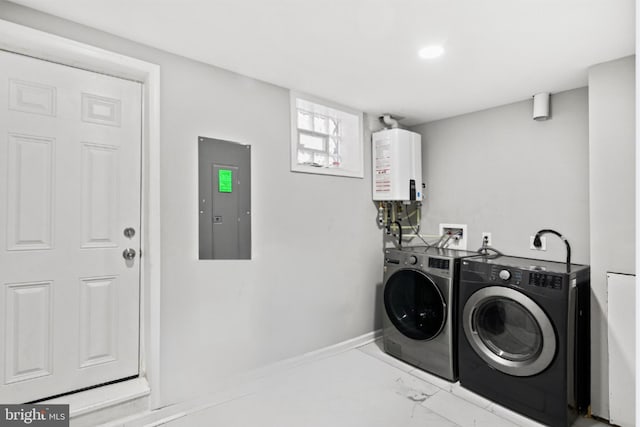 clothes washing area with washing machine and clothes dryer, electric panel, and water heater