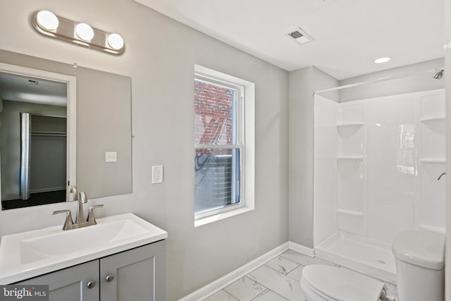 bathroom with a shower, vanity, and toilet