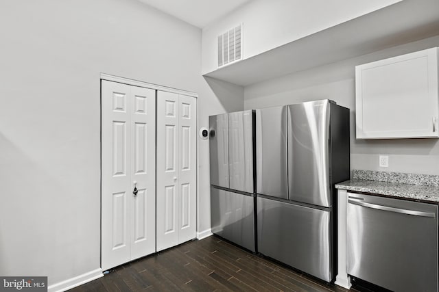 kitchen with white cabinets, dishwasher, light stone countertops, and dark wood-type flooring