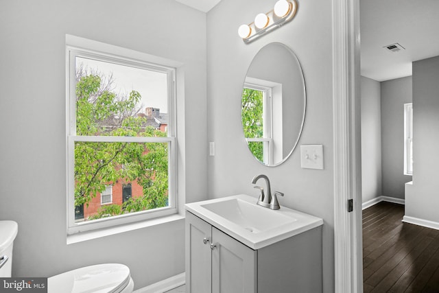 bathroom with hardwood / wood-style floors, vanity, and toilet