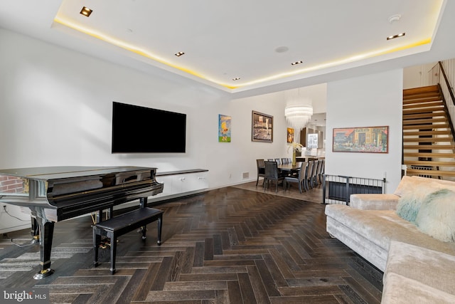 living room featuring a raised ceiling and dark parquet floors