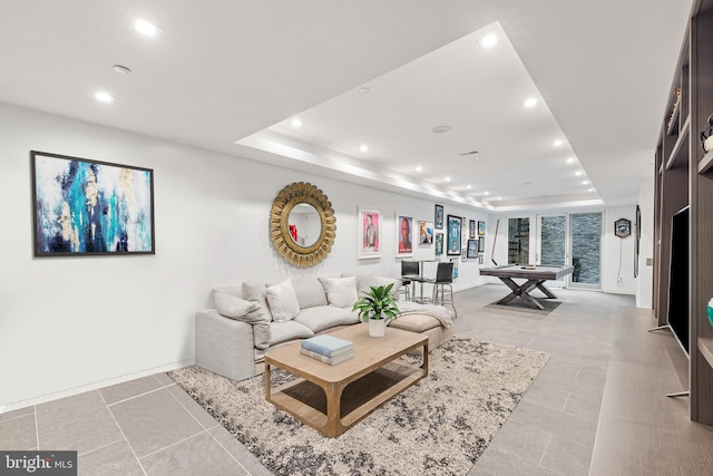 tiled living room with a tray ceiling and pool table