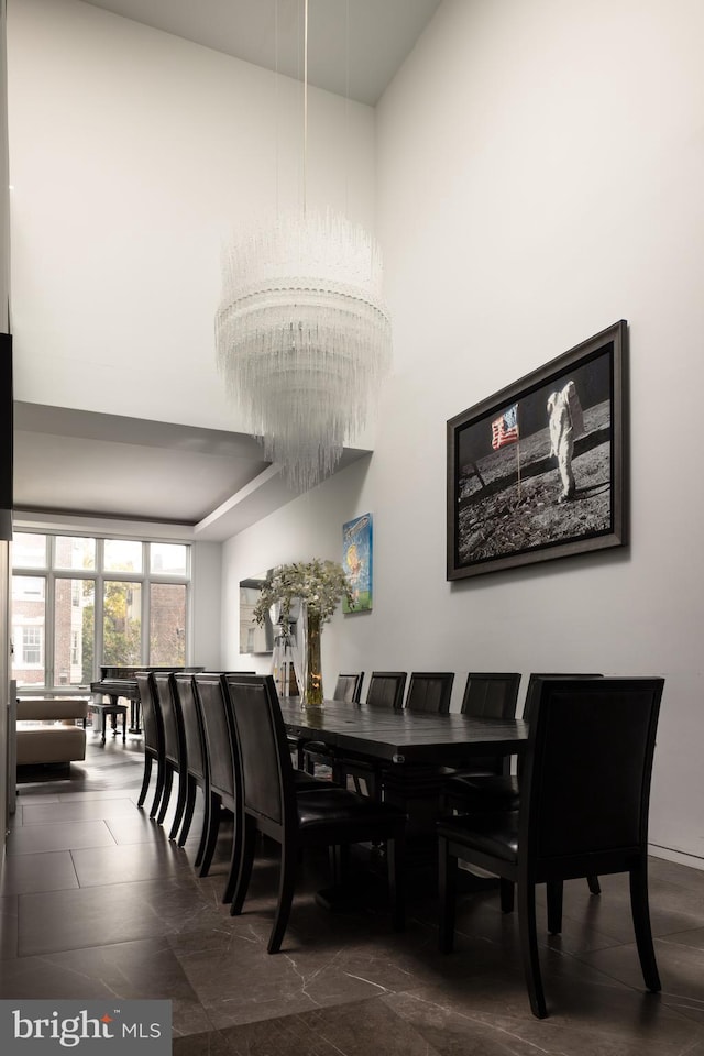 dining area with a high ceiling and an inviting chandelier