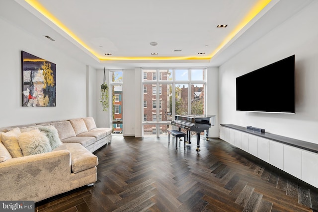 living room with a tray ceiling and dark parquet flooring