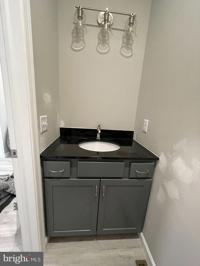 bathroom featuring wood finished floors, vanity, and baseboards