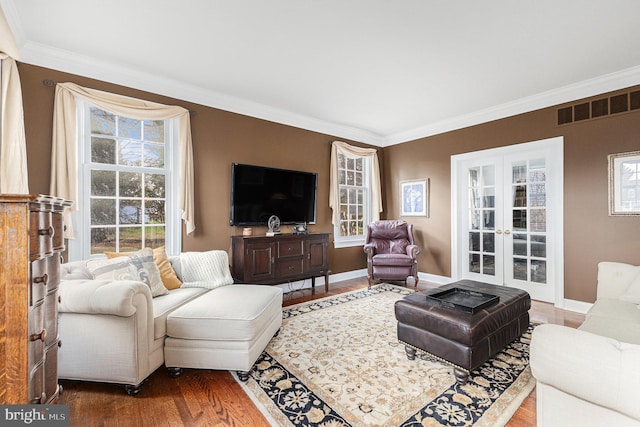 living room featuring french doors, wood-type flooring, and ornamental molding