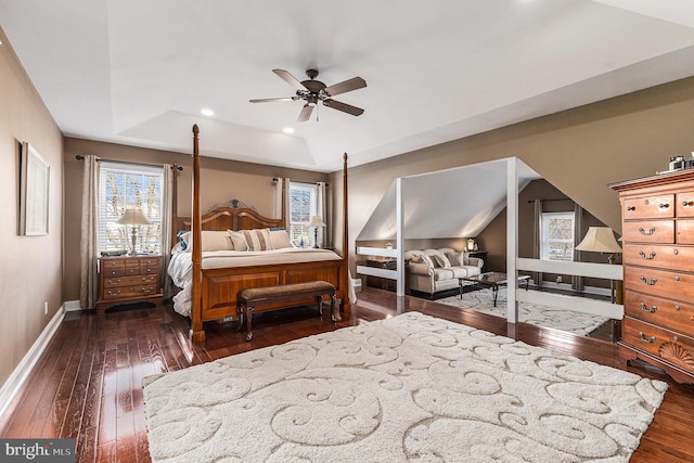 bedroom with a tray ceiling, ceiling fan, and dark wood-type flooring