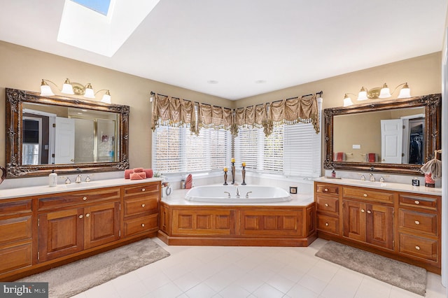 bathroom with tile patterned flooring, a bathtub, vanity, and a skylight