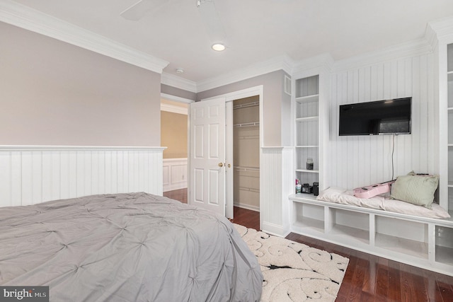 bedroom featuring a closet, hardwood / wood-style floors, ceiling fan, and crown molding