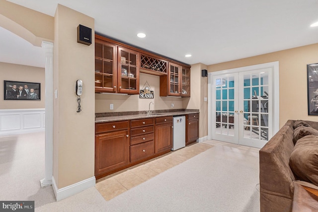 kitchen with french doors, white dishwasher, light colored carpet, and sink