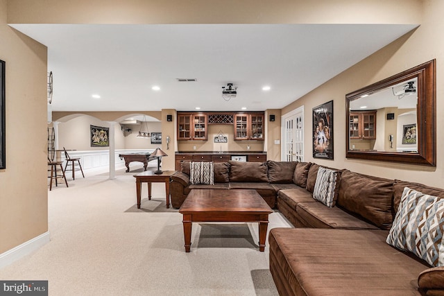 living room featuring bar, french doors, and light colored carpet