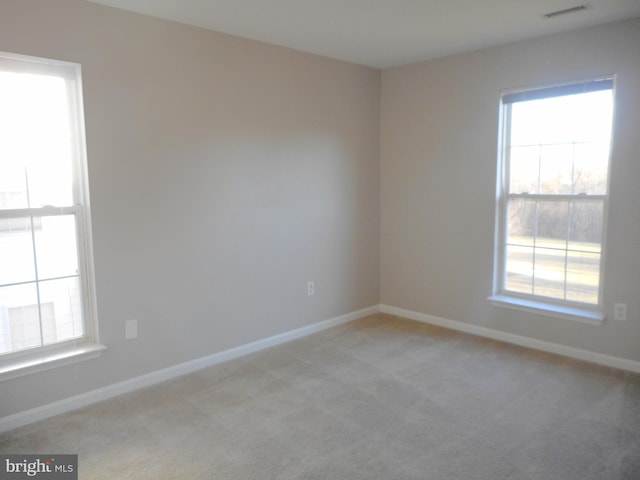 spare room featuring light colored carpet