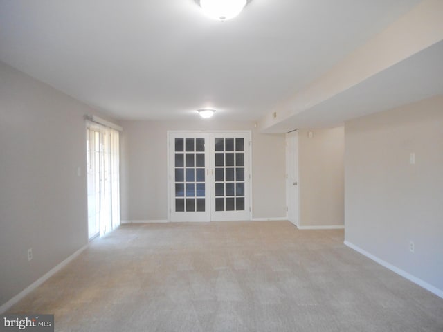 spare room featuring french doors and light carpet