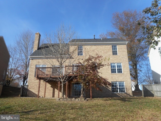 rear view of house featuring a yard and a deck