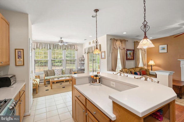 kitchen featuring light tile patterned floors, decorative light fixtures, a kitchen island, and ceiling fan